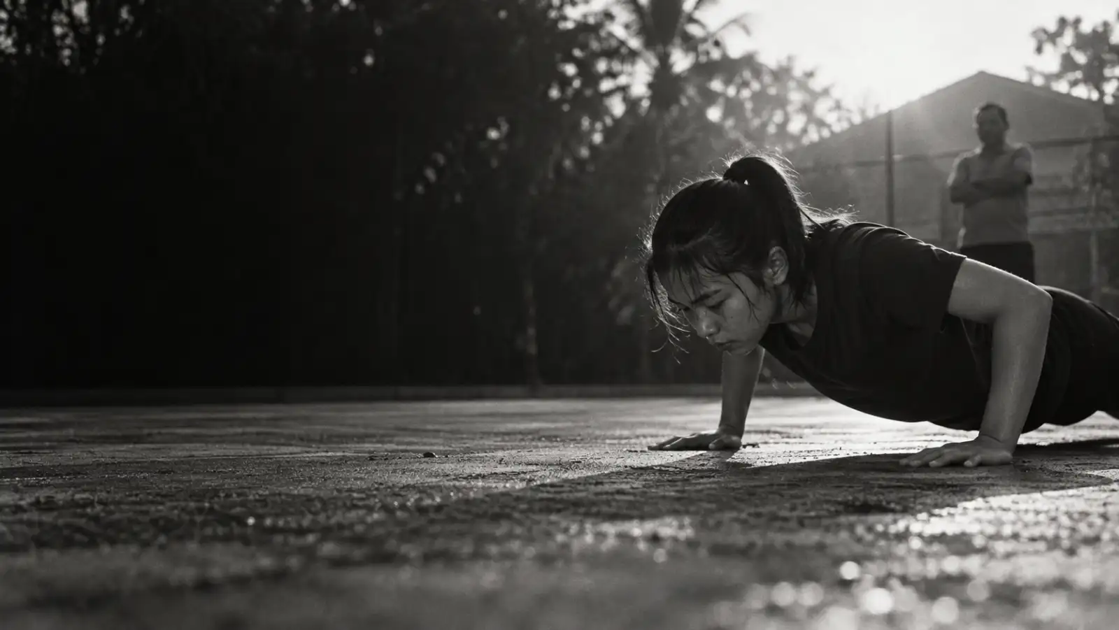 Foto hitam putih remaja melakukan push-up di lapangan saat pagi